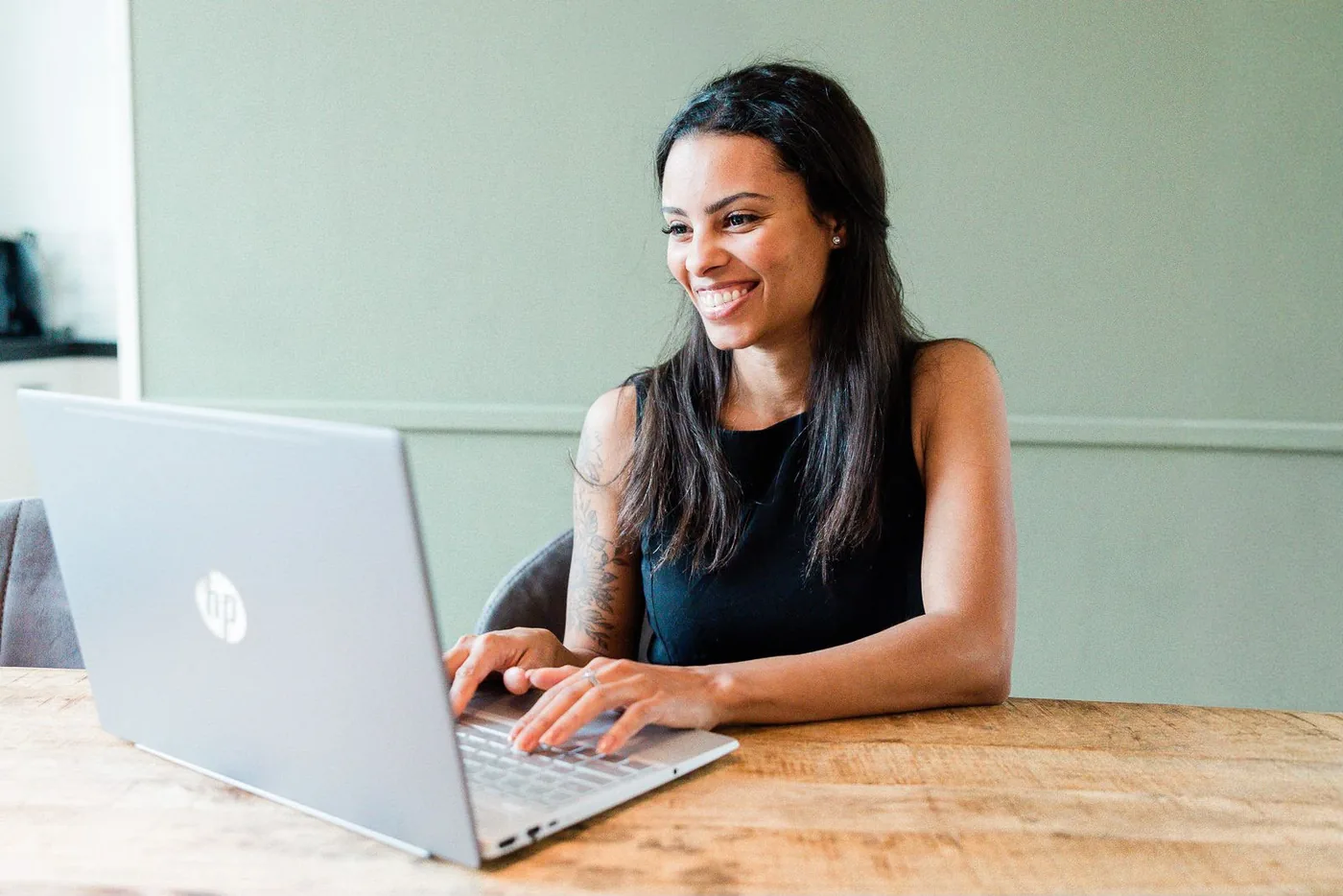 Amy werkt lachend aan haar laptop