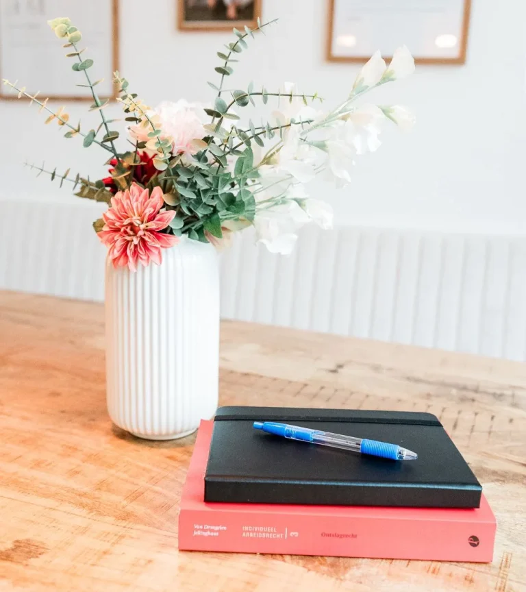 Bloemen, notitieboek en boek over ontslagrecht op tafel