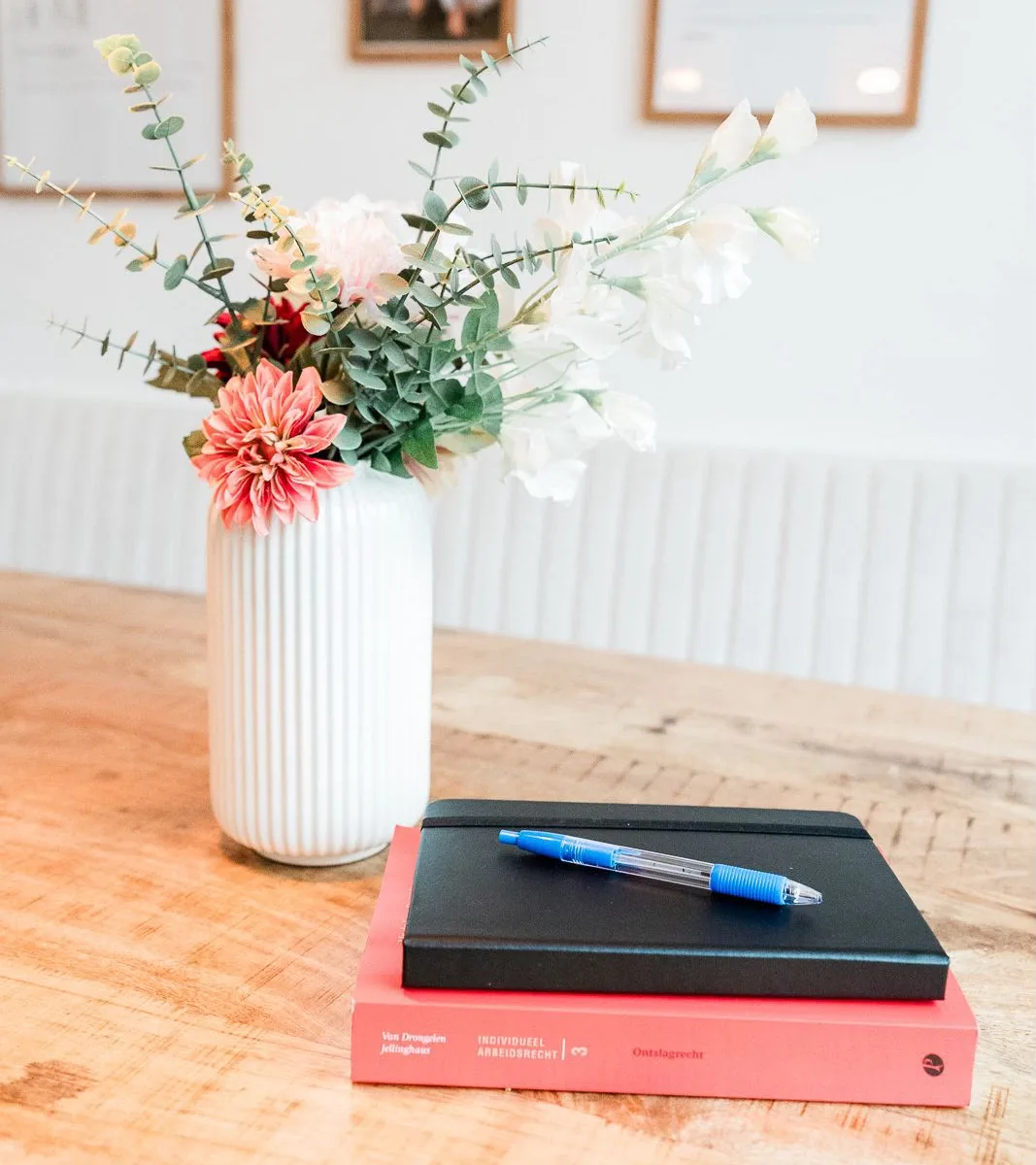 Bloemen, notitieboek en boek over ontslagrecht op tafel